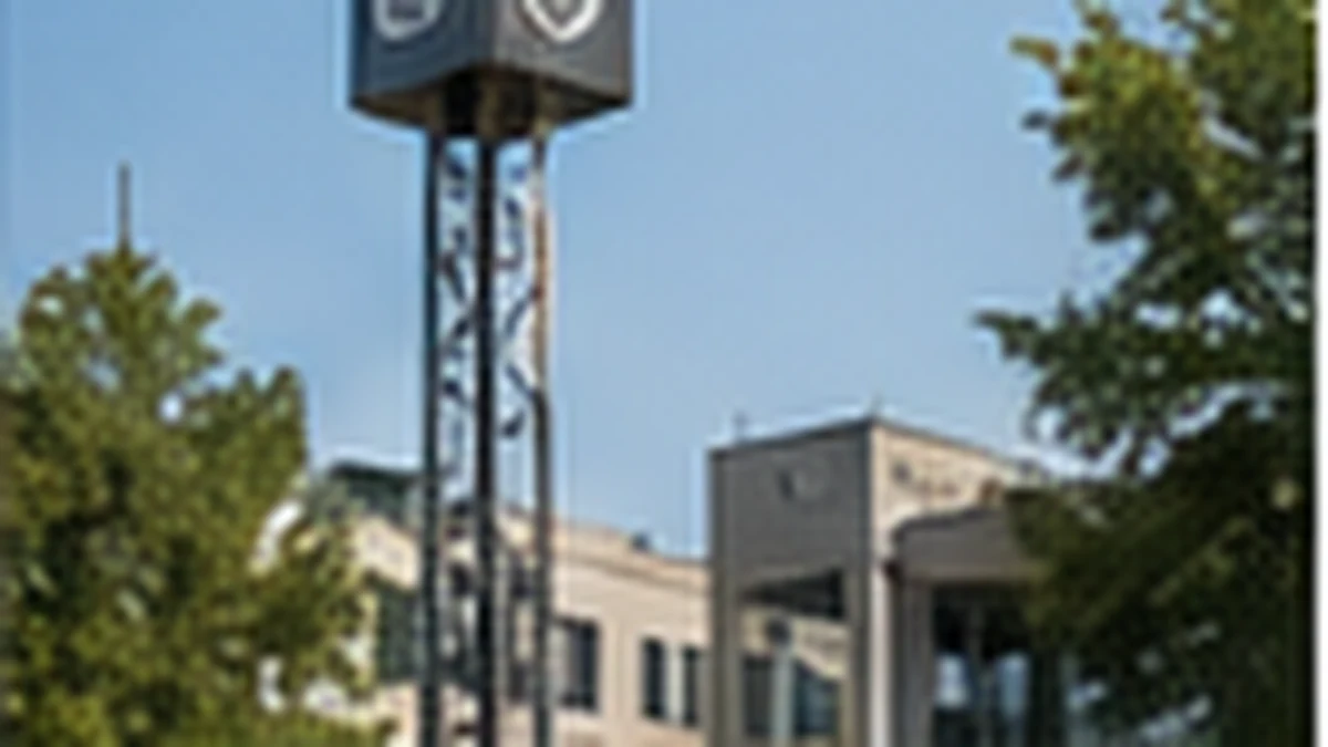 Water tower beside a low commercial building on a sunny day